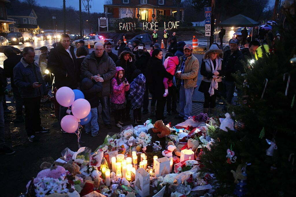 Members of the public paying their respects at the shrine set up around the towns Christmas tree in Sandy Hook after the mass shootings at Sandy Hook Elementary School, Newtown, Connecticut, USA. 16th December 2012. Photo Tim Clayton (Photo by Tim Clayton/Corbis via Getty Images)
